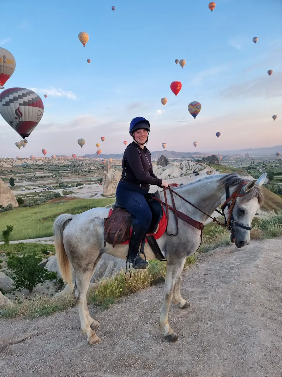 sunset horse riding cappadocia with warm light over valleys